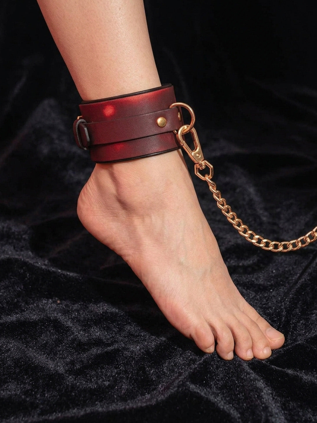 Wrist Cuffs Ankle Cuffs, close up of leather ankle cuff with connecting gold chain