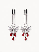 pair of silver bat wing jewelry for nipple with red teardrop crystal pendants black silicone tips isolated on white background gothic style couples gifts