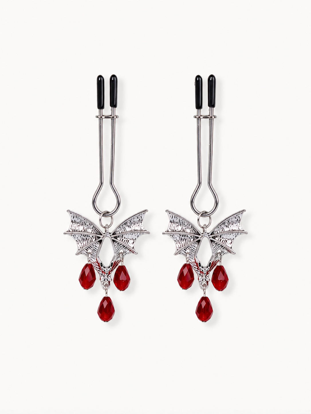 pair of silver bat wing jewelry for nipple with red teardrop crystal pendants black silicone tips isolated on white background gothic style couples gifts
