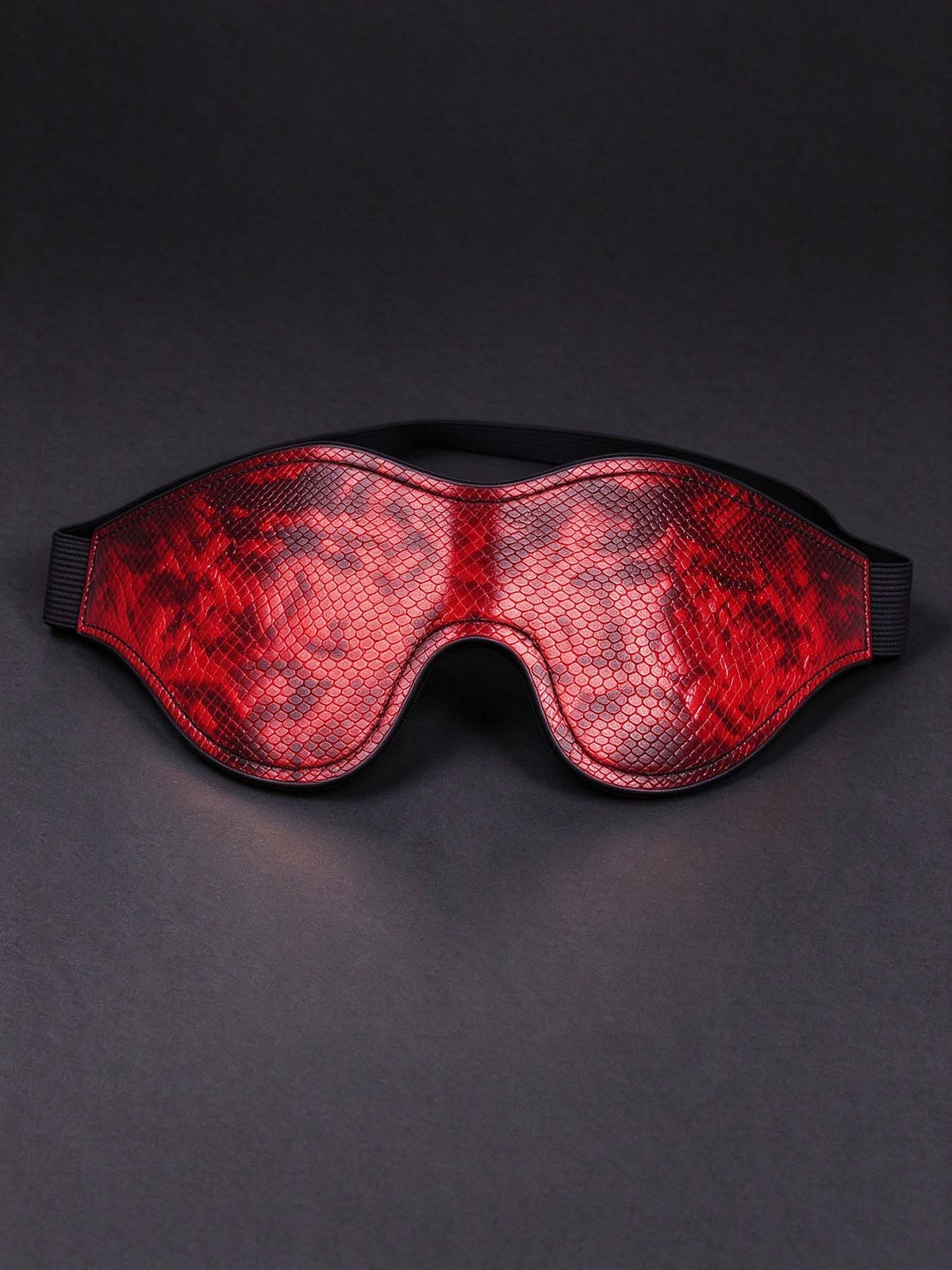 red snake print leather eye mask contoured eye shape black elastic strap faux leather sleep mask dark grey background stylish sleeping accessory