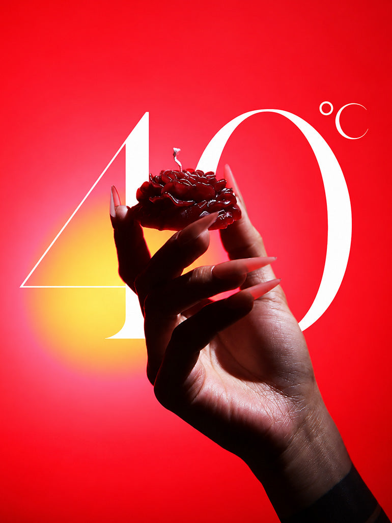 Low Temp Wax Play Candles, red rose candle held on bright red background marked with 40 degree celsius label