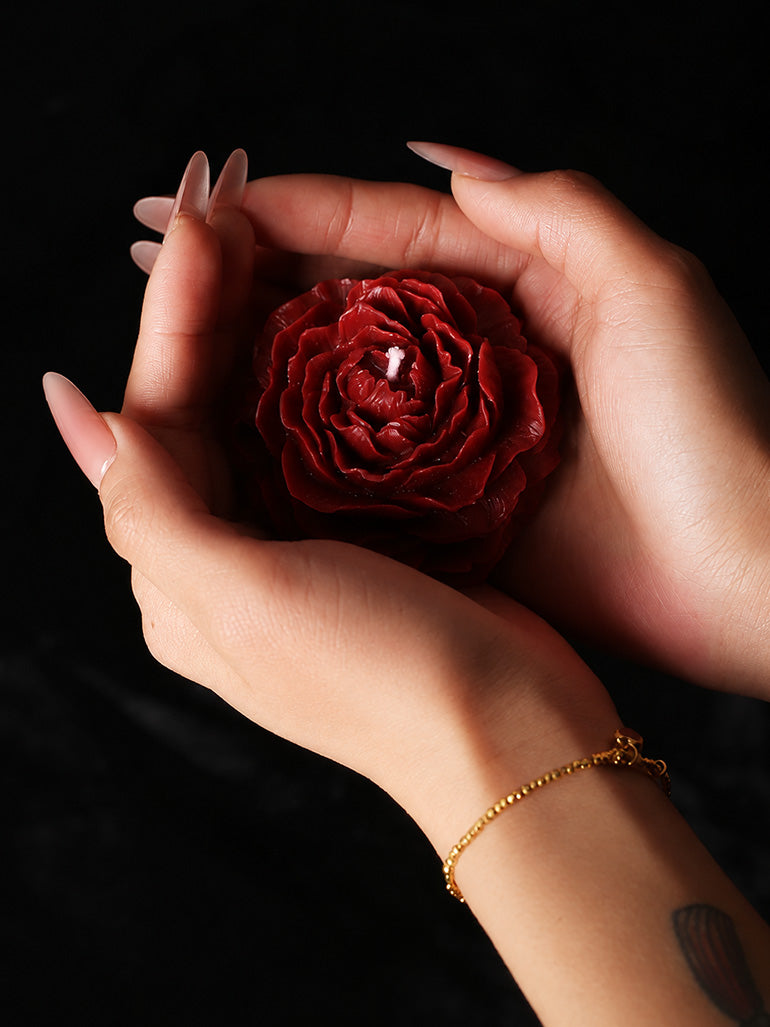 Low Temp Wax Play Candles, red rose candle cupped by hands wearing delicate thin gold bracelet