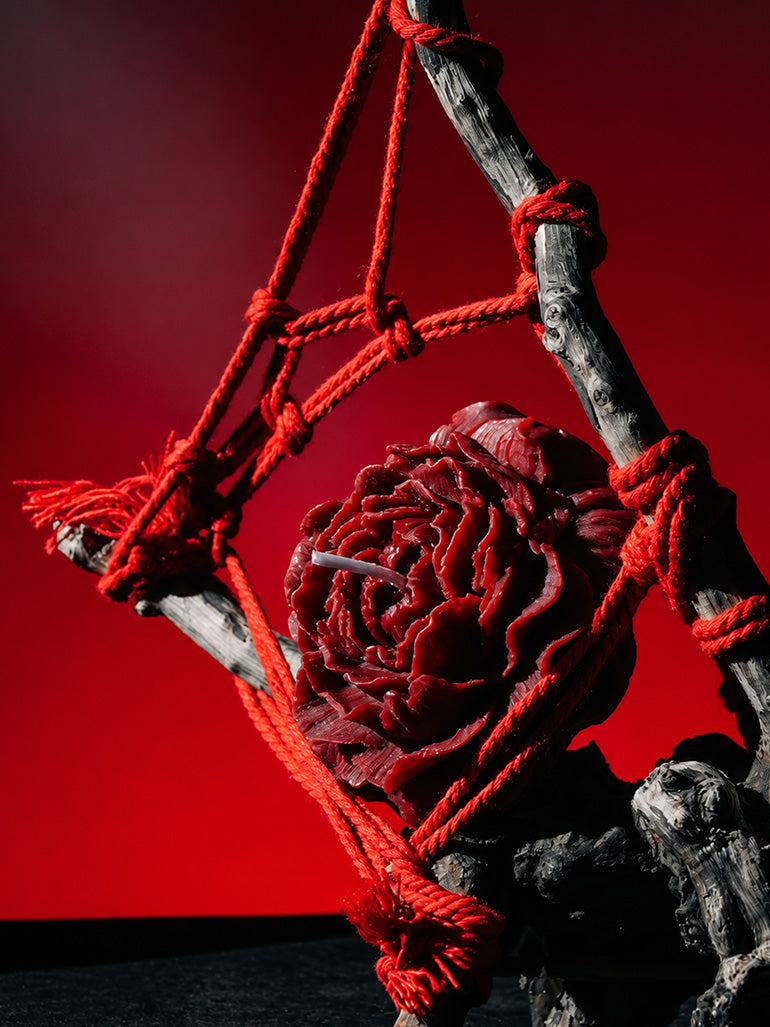 Low Temp Wax Play Candles, red rose candle styled with red rope and twig decor against bold red backdrop