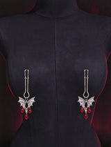 gothic bat nipple clamps antique silver bat charm with teardrop red crystal pendants displayed on black fabric mannequin dark red mood background goth decorative fashion jewelry