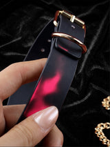 Thermochromic leather choker necklace held in hand, pink black gradient temperature-sensitive color changing leather, gold D ring and buckle, showing heat-activated color change effect