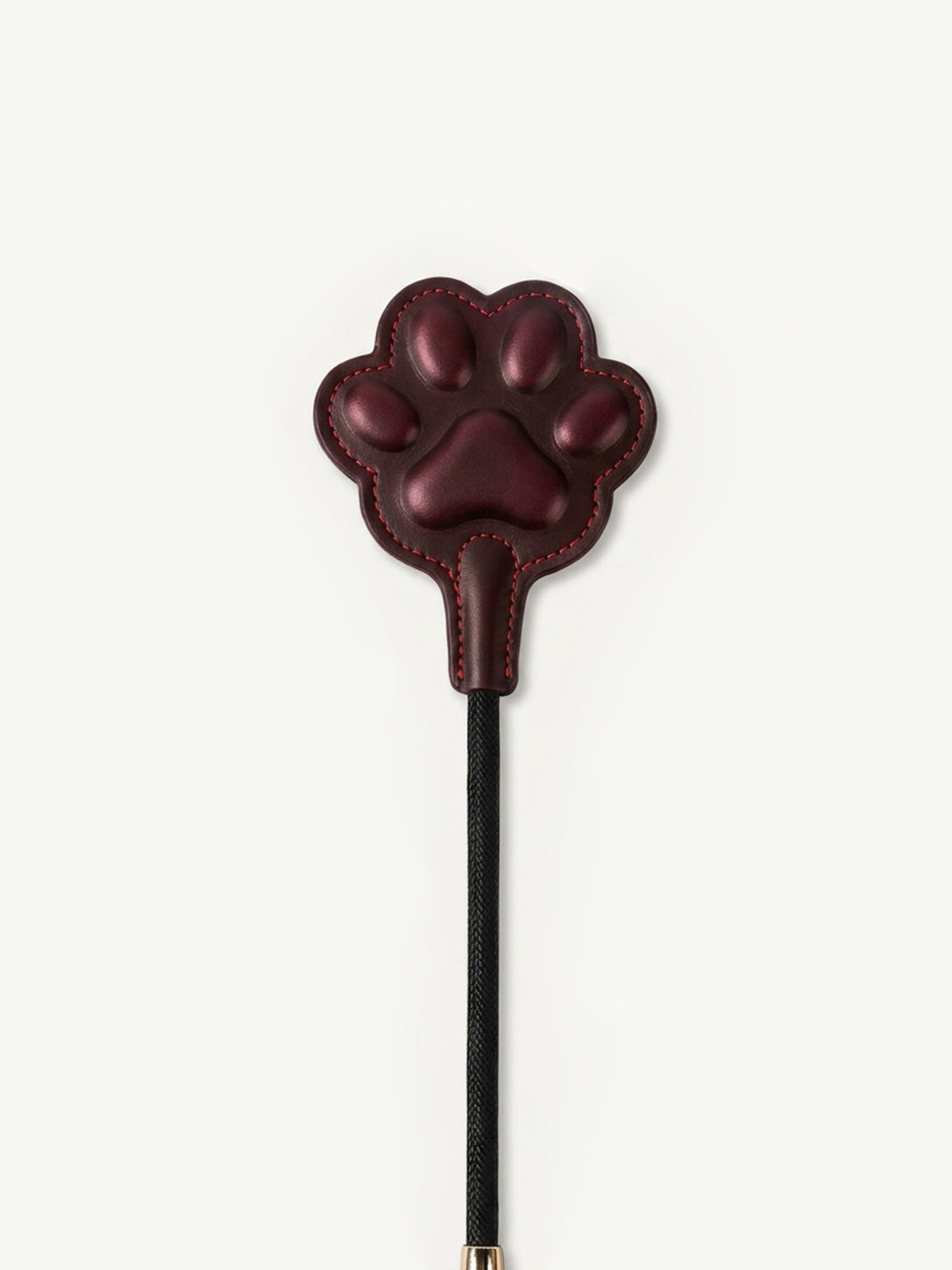 Product photo of thermochromic leather paw paddle, dark red gradient paw shaped pad with red stitching, black braided handle and gold end cap on white background