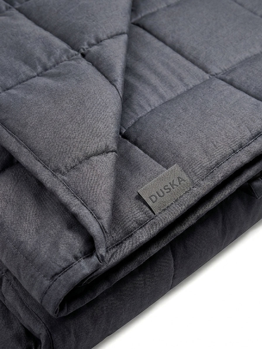 Close-up of a weighted blanket's quilted texture and Duska fabric label
