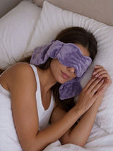 Woman curled up wearing a weighted sleeping mask, ideal weighted eye mask for side sleepers
