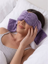 Woman smiling while resting in a weighted eye mask, a luxury eye mask designed for deep sleep